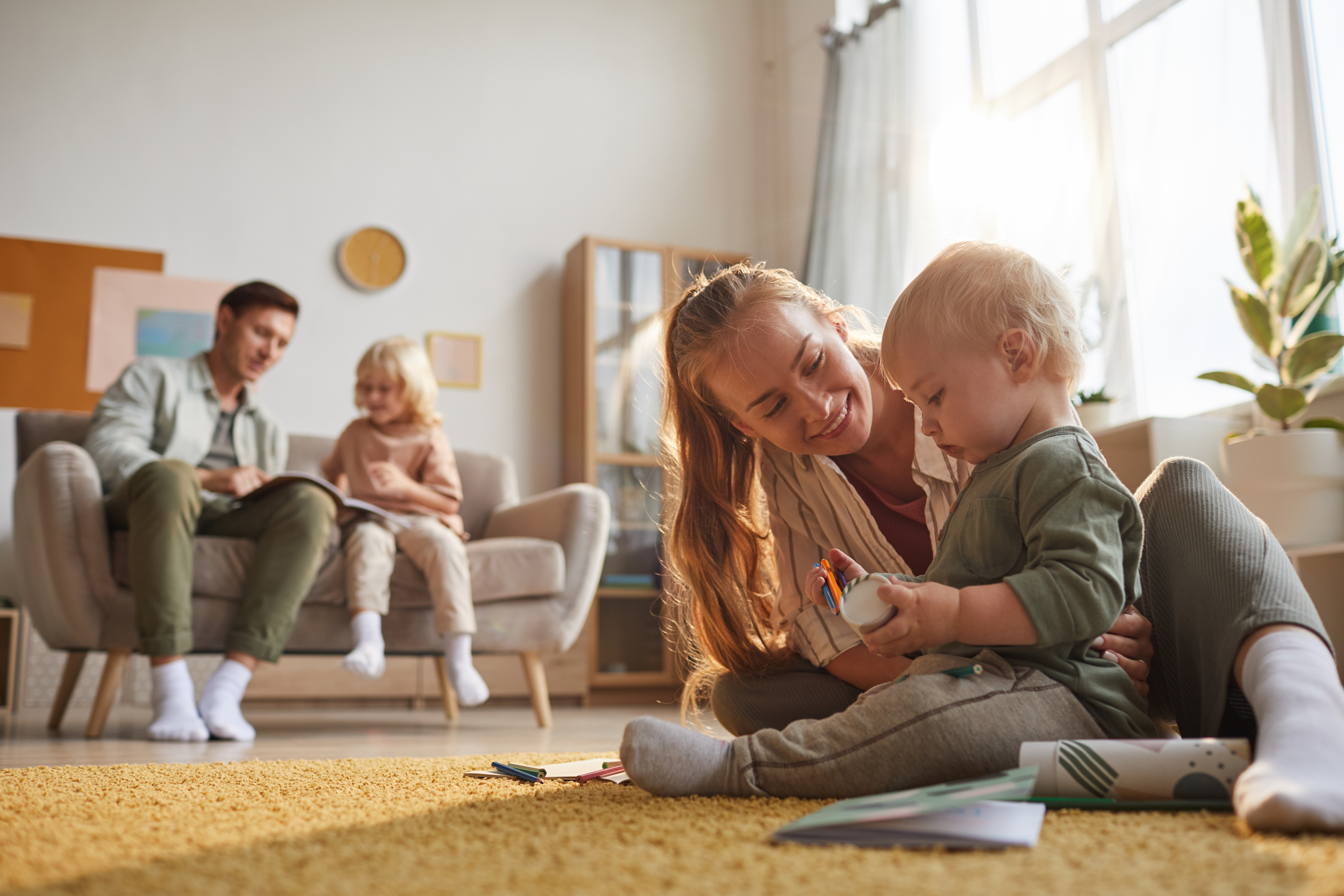 Obrázek happy-mother-playing-with-her-baby-floor-father-playing-with-older-son-room.jpg