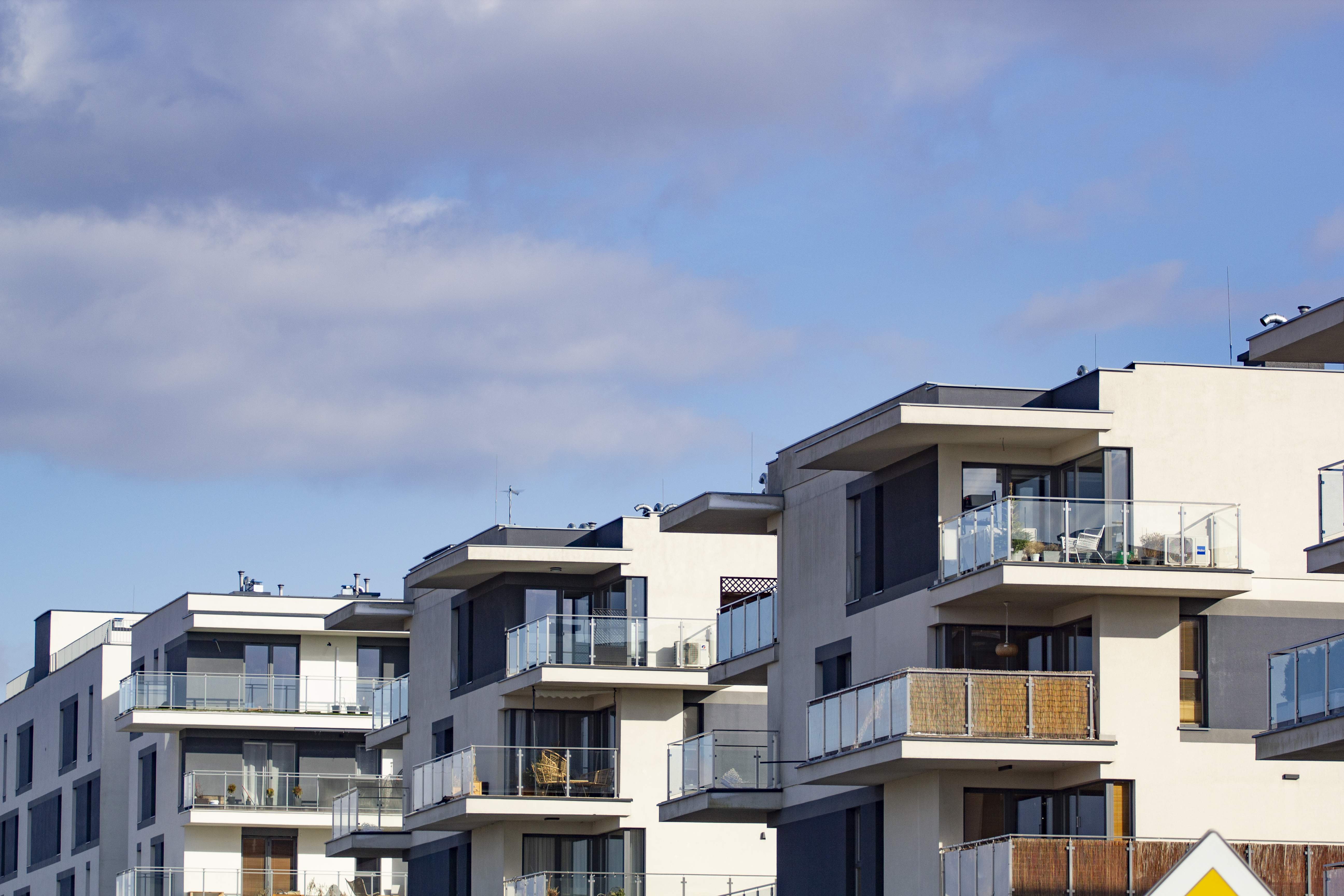Obrázek row-apartment-buildings-with-balconies-blue-sky.jpg